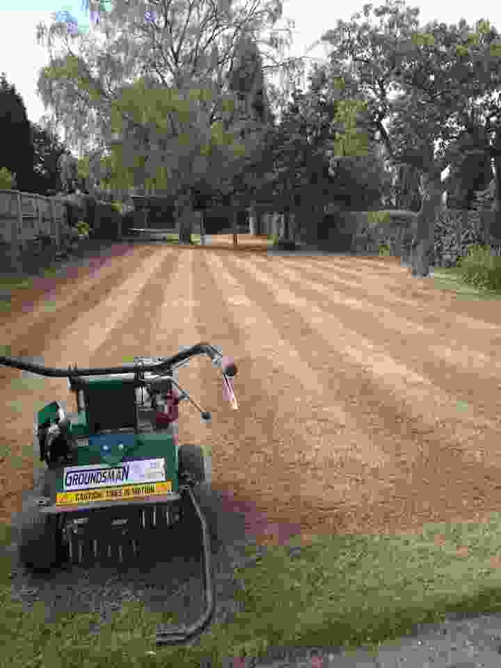 This image is following lawn renovation, a large lawn that has bee neatly cleared up and ready to aerate. Our machine is ready for work in the foreground 