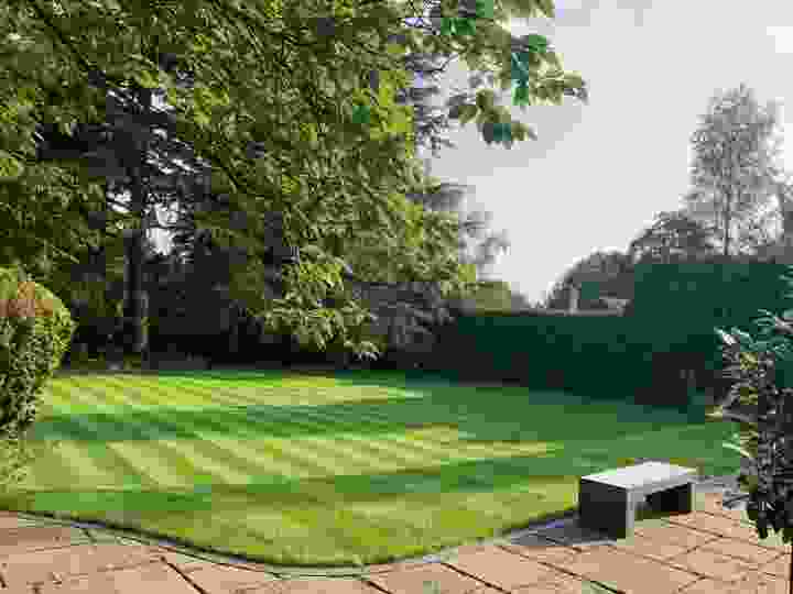 This image is of a lawn which benefits from our lawn treatment service. It has been recently mown in very straight lines and a deep green colour