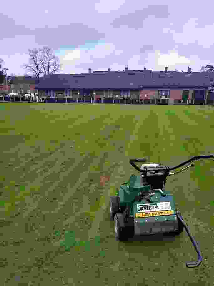 This image is of a bowling green near Coventry with a large aeration machine at work carrying out one of our lawn maintenance programs
